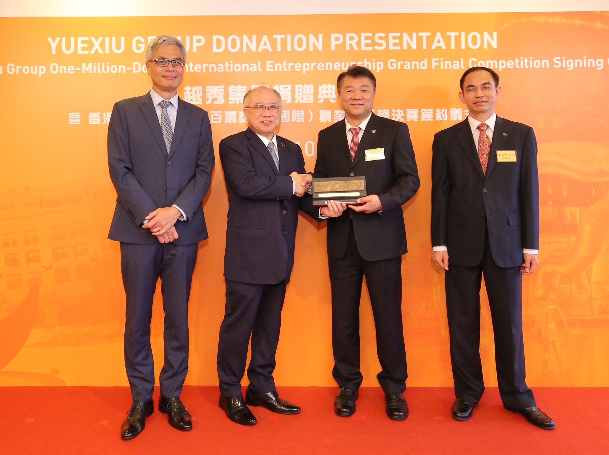 廖長城先生（左二）及史維教授（左一）致送紀念品予張招興先生（右二）和朱春秀先生（右一）。