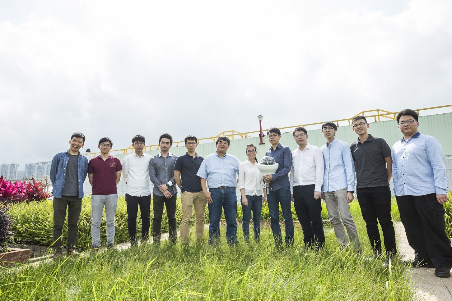 Prof. Wang (Left sixth) and his research team are developing the fourth generation of the sensor that can harvest energy from solar panel and conduct data analytics by AI.