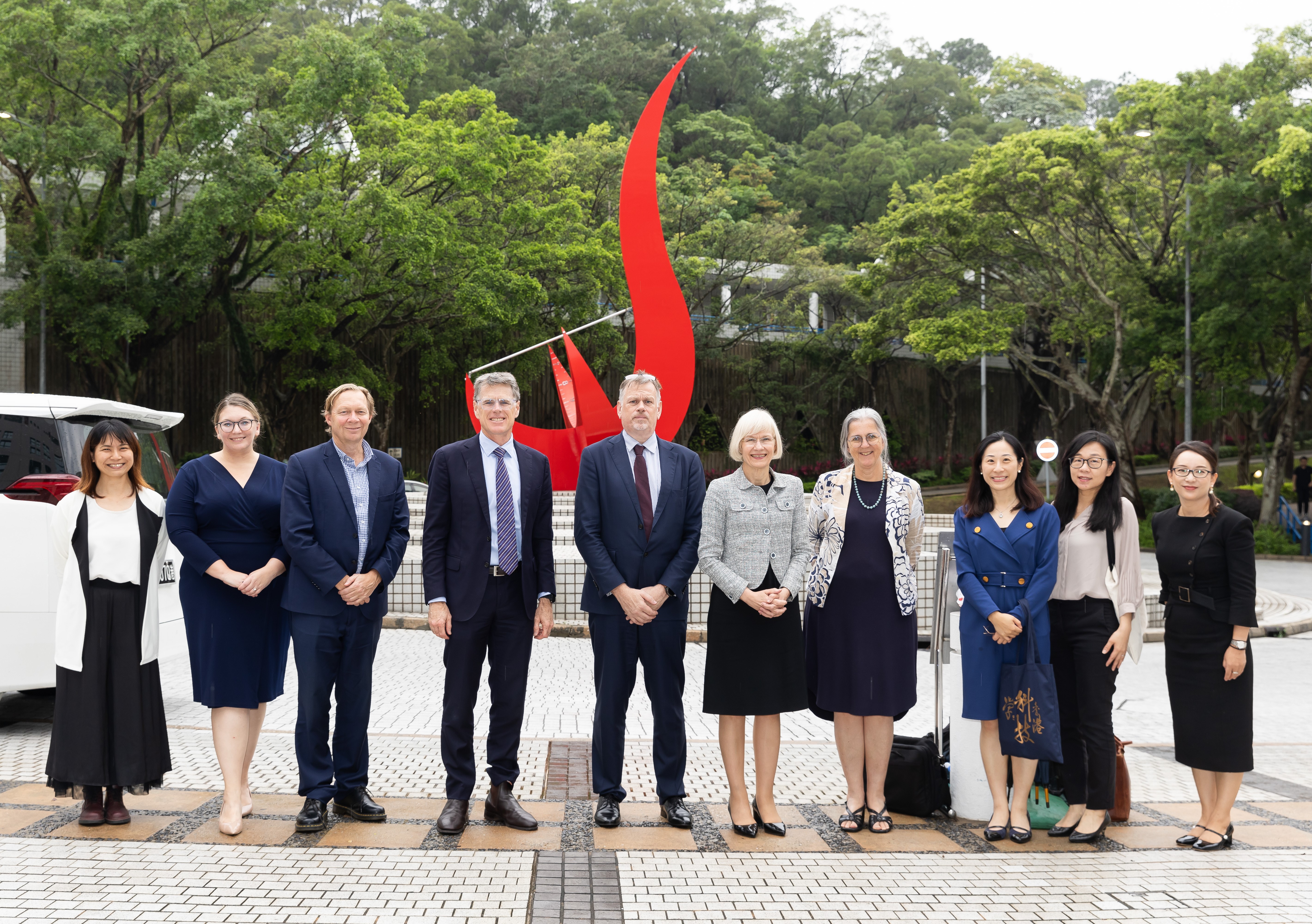 昆士兰大学代表团在科大广场红鸟日晷标志前留影。