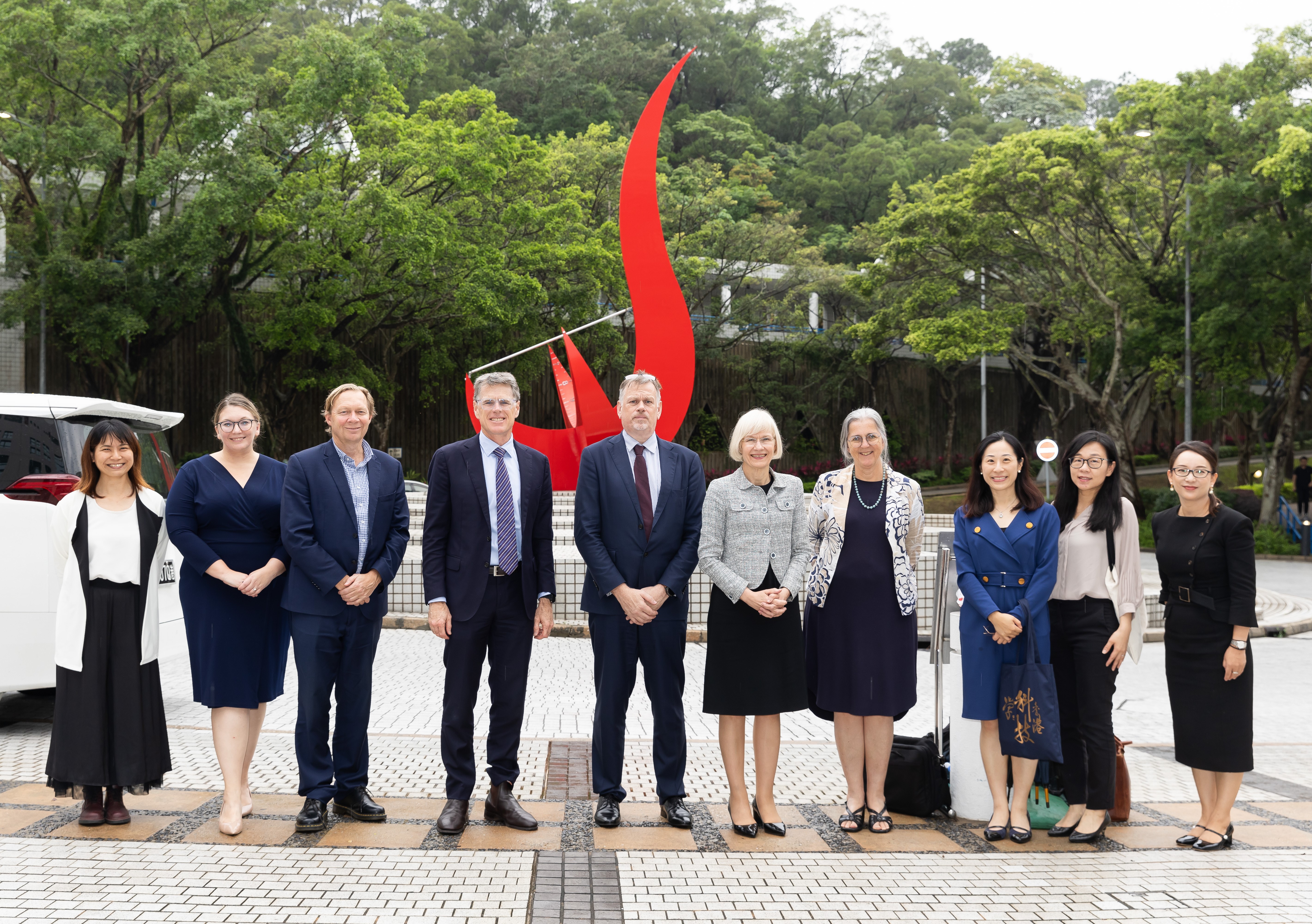 Photo of the University of Queensland delegation in front of the iconic “Red Bird” sculpture at the Piazza.