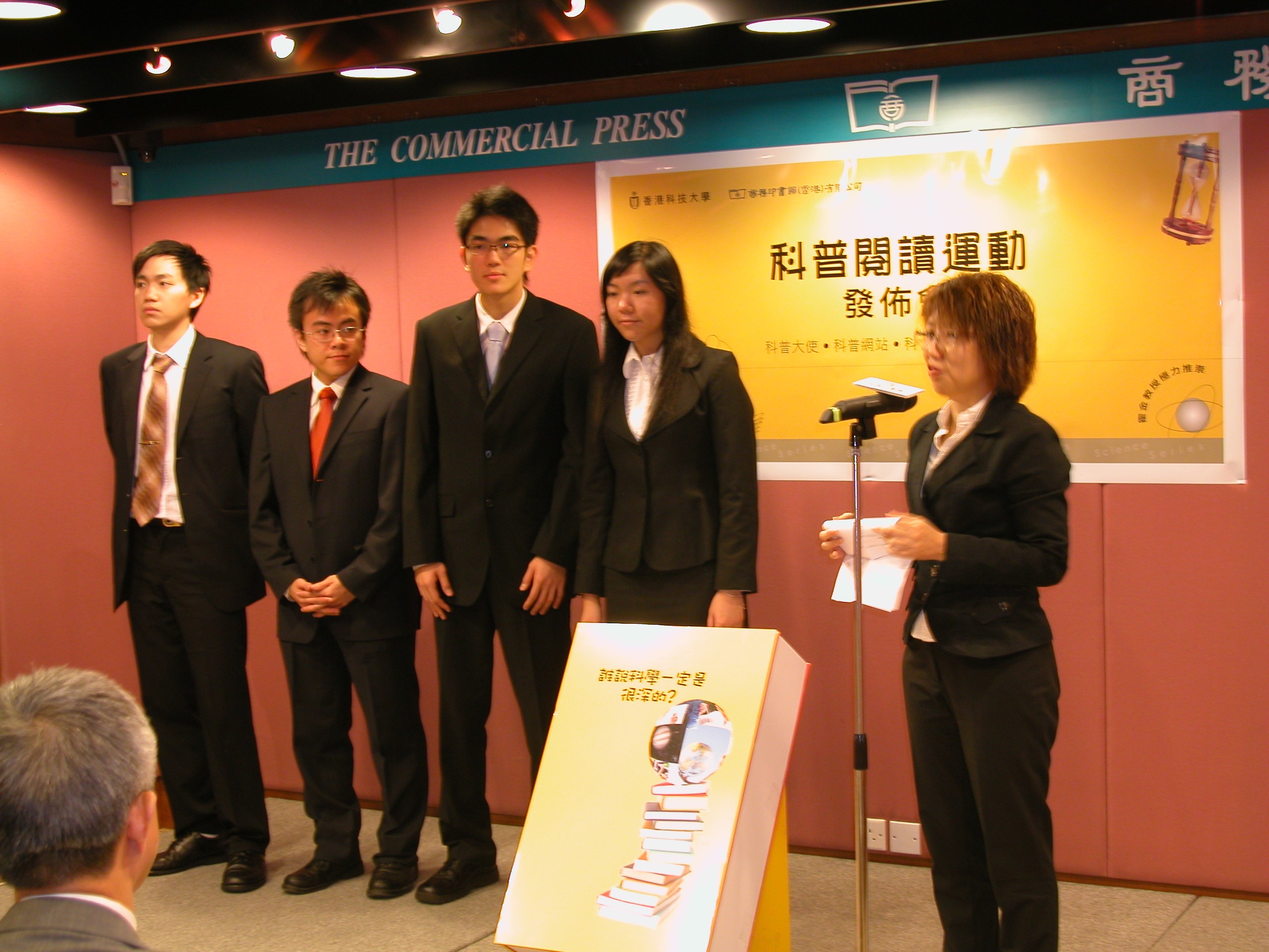 香 港 商 务 印 书 馆 总 编 辑 张 倩 仪 女 士 介 绍 四 位 出 席 的 科 大 学 生 「 科 普 大 使 」 。 左 起 ： 陈 俊 杰 （ 主 修 物 理 / 数 学 双 学 位 ） 、 蔡 瑞 聪 （ 主 修 物 理 ） 、 李 德 文 （ 主 修 物 理 / 数 学 双 学 位 ） 、 及 何 淑 欣 （ 主 修 物 理 ）	
