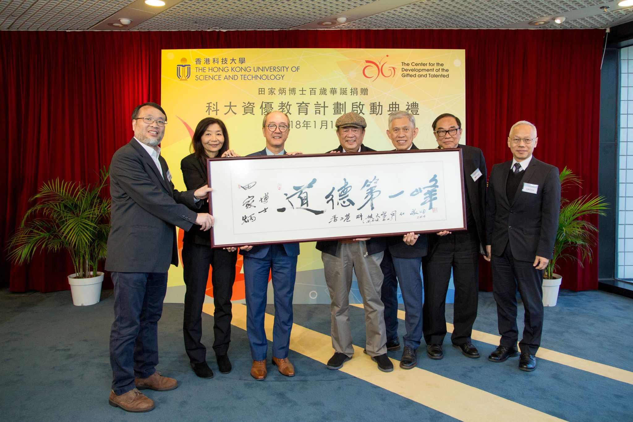  科大向基金会代表致送由刘再复教授题写的横匾，庆祝田家炳博士百岁寿辰。（左起）科大资优教育发展中心总监周敬流教授、副校长(大学拓展) 林文怡博士、校长陈繁昌教授、著名文学家及田家炳中国文学驻校杰出校人刘再复教授、田家炳基金会董事局主席田庆先先生、副主席戴希立先生及董事田荣先先生