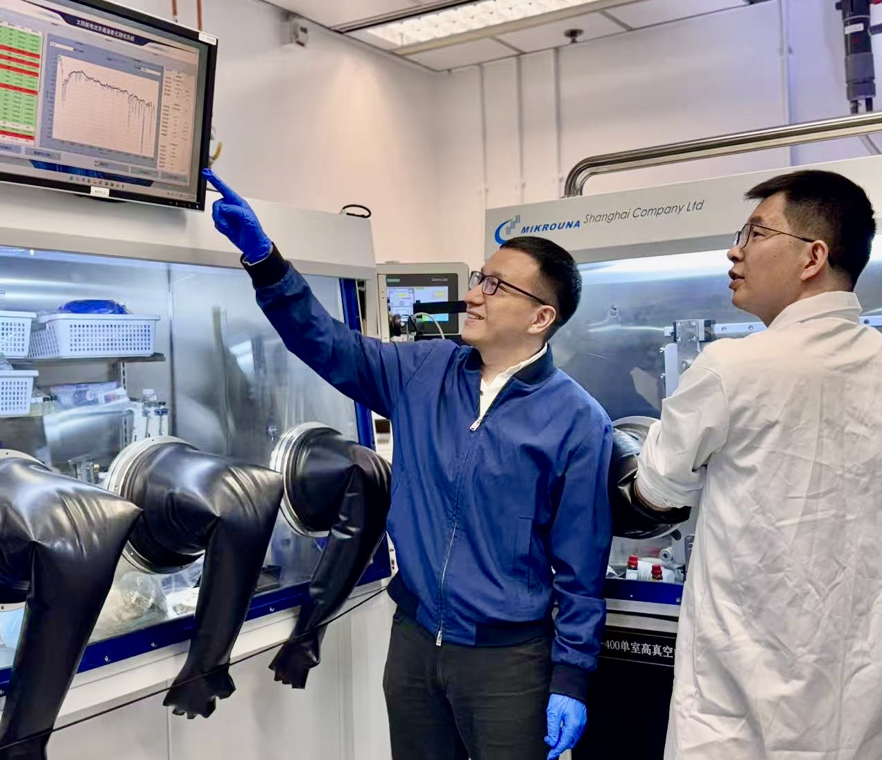 Prof. Zhou Yuanyuan (left) is guiding Dr. Guo Pengfei (right) in analyzing the stability test results of perovskite solar cells based on laminated-structured interfaces.