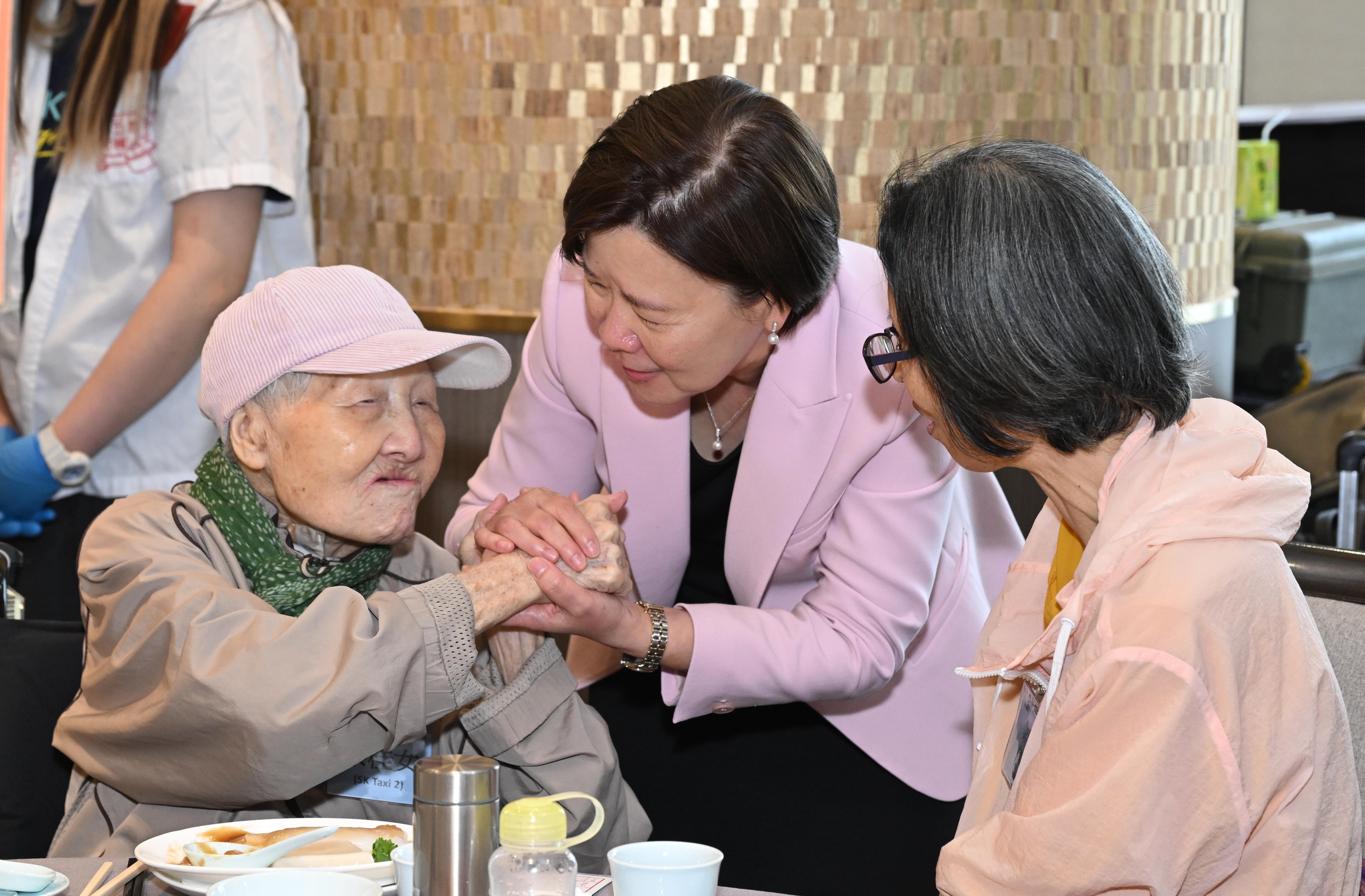 President Prof. Nancy Ip (middle) interacts with a participating senior and her caregiver. 
