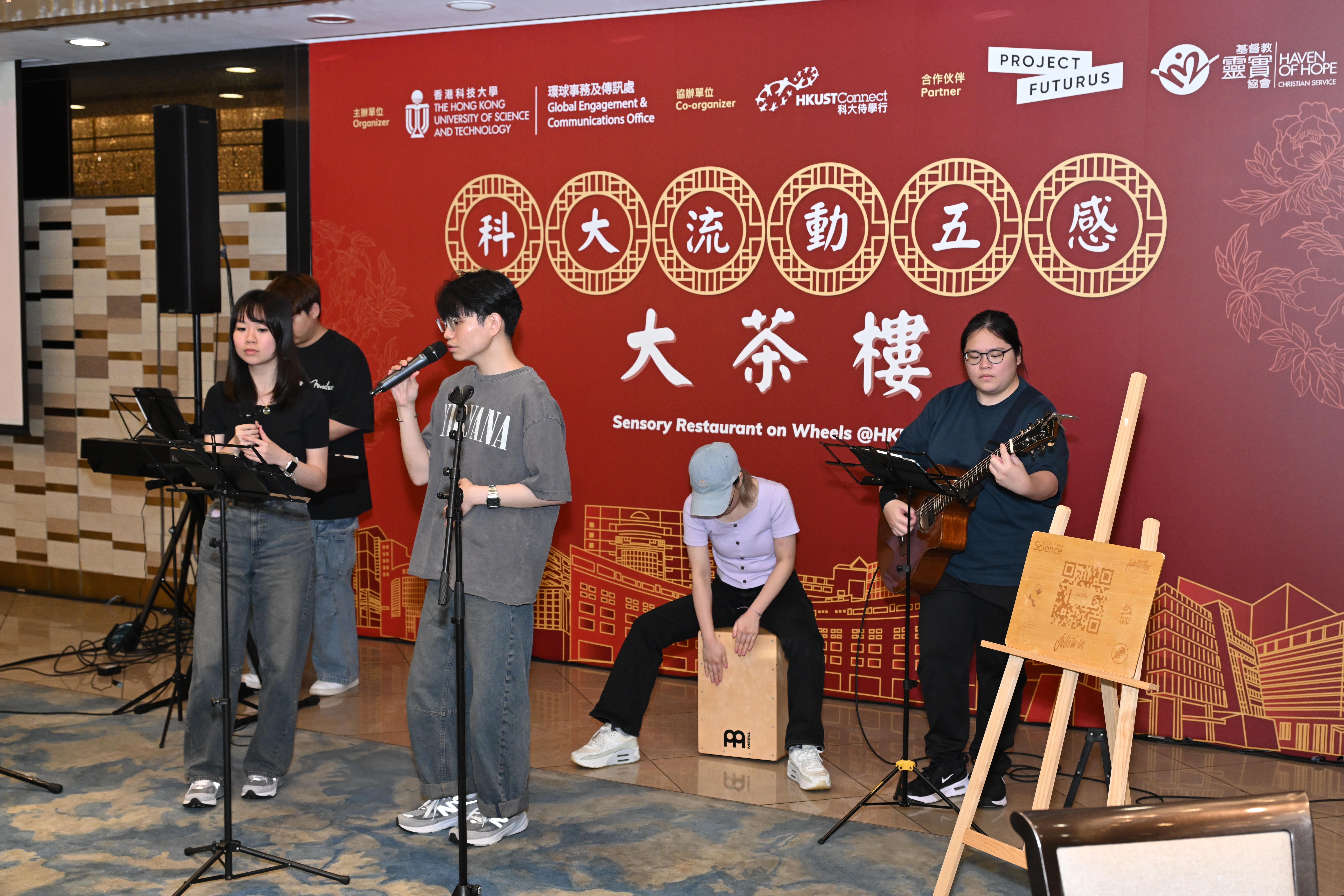 A live band composed of science students from HKUST Particles performs classic canto pop songs - “City of Hope” and “Below the Lion Rock”.  