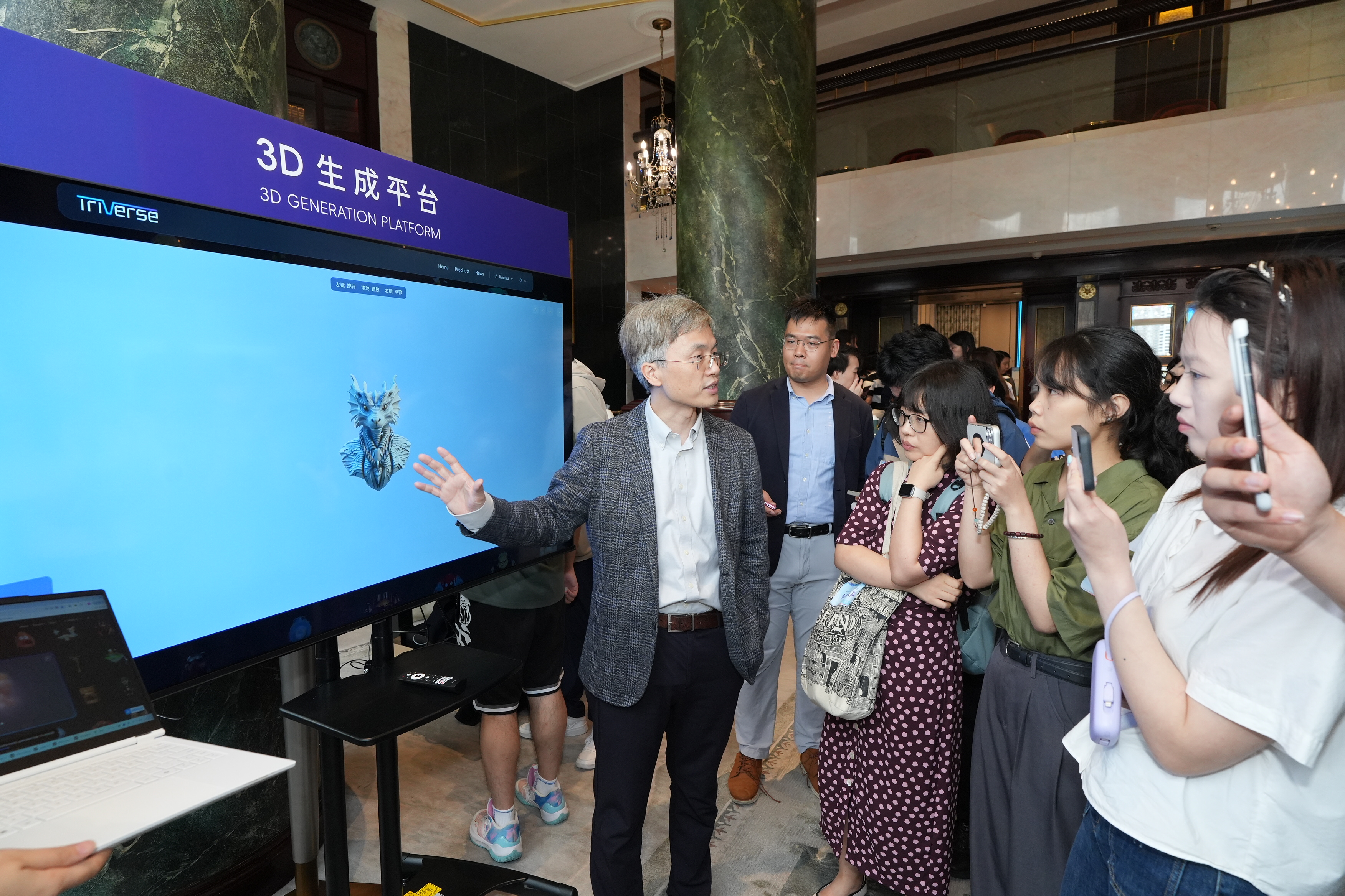 譚平教授（左一）簡介其開發的3D生成平台。該平台目前已開放予公眾於triverse.ai網站試用。