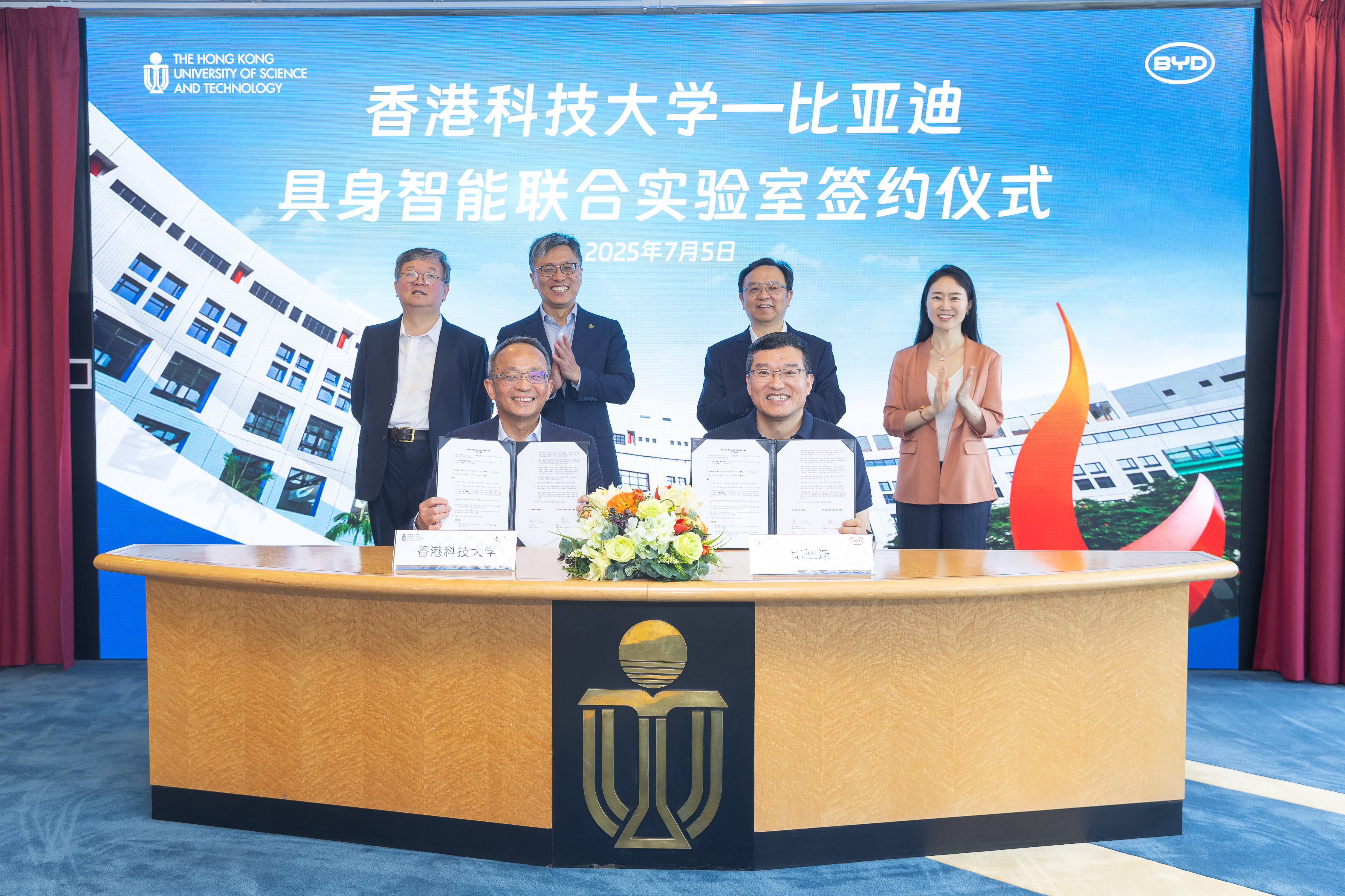 在沈向洋教授 (后排左二) 、王传福先生 （后排右二）、科大首席副校长郭毅可教授（后排左一）及比亚迪副总裁李巍女士（后排右一）的见证下，郑光廷教授 (前排左)与罗忠良先生 (前排右)签署协议。