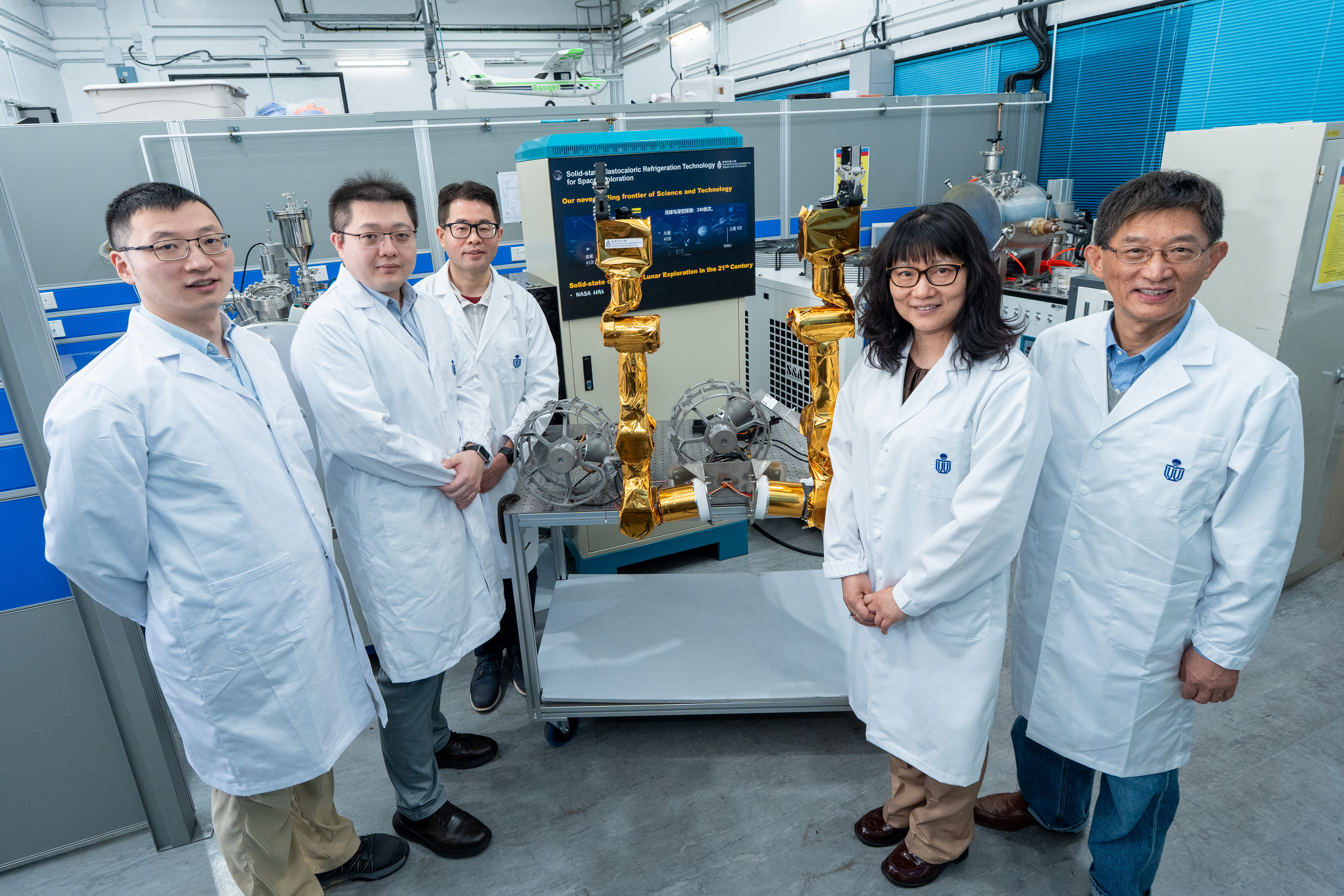 A group photo of five HKUST scholars who are leading the international "Hong Kong Operation Robot" project. From left to right: Prof. Walter WANG Zhe, Associate Professor of the Department of Civil and Environmental Engineering; Prof. DUAN Molong, Assistant Professor of the Department of Mechanical and Aerospace Engineering; Prof. SHI Ling, a Professor in both the Department of Electronic and Computer Engineering and the Department of Chemical and Biological Engineering; Prof. GAO Yang, Professor of the Dep