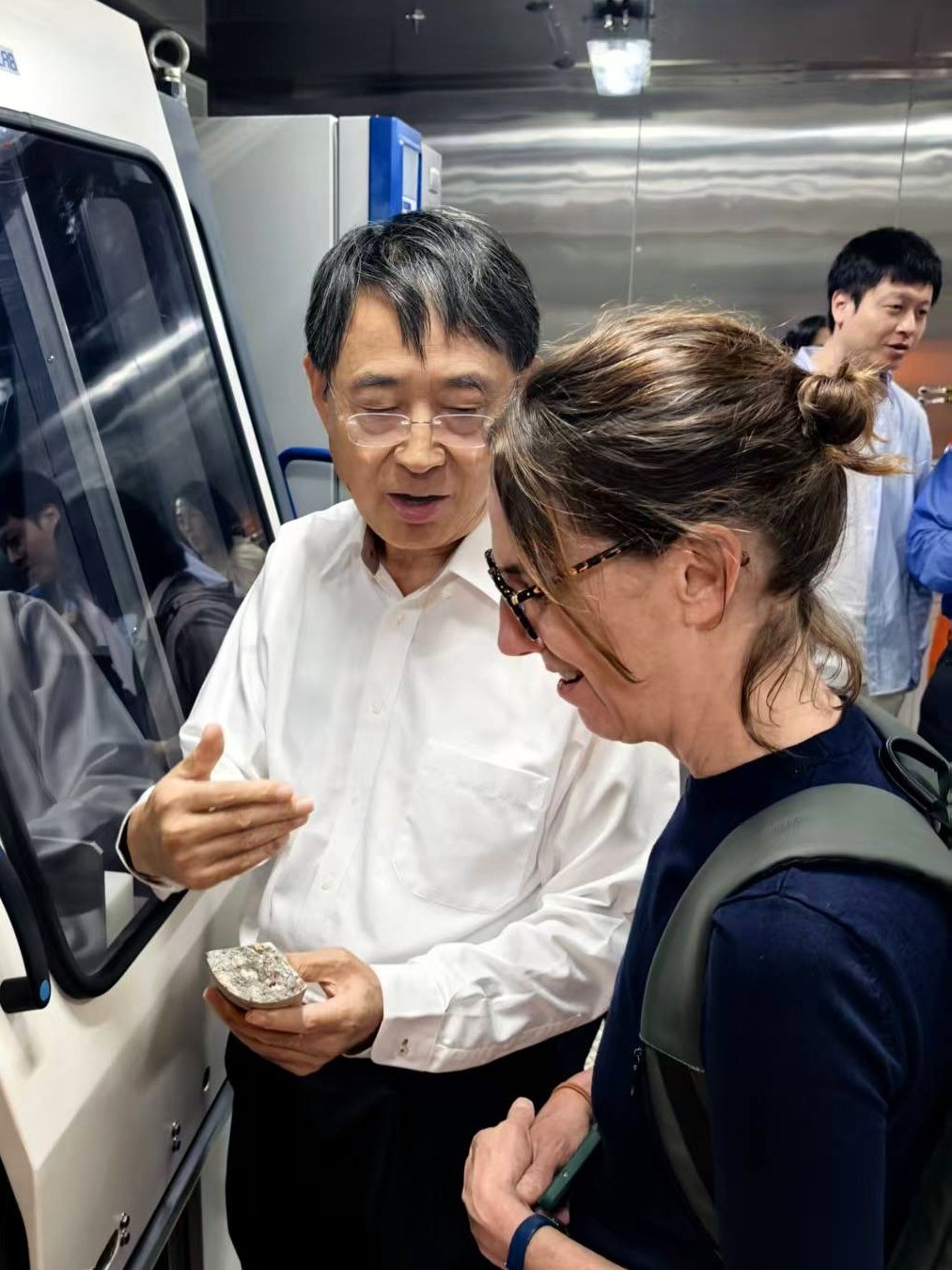 Prof. Qian shows Ms. Alison Clausen a core sample collected from the deep sea