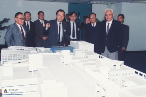  钟博士（前左一）于1992年为到访科大的时任国务院港澳办公室主任鲁平（前右一）介绍科大发展计划。