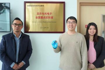 Dr. Shen Xinyi (center) holds his certified all-vacuum-deposited perovskite solar cell with Prof. Lin Yen-Hung (left) and Dr. Fion Yeung (right).